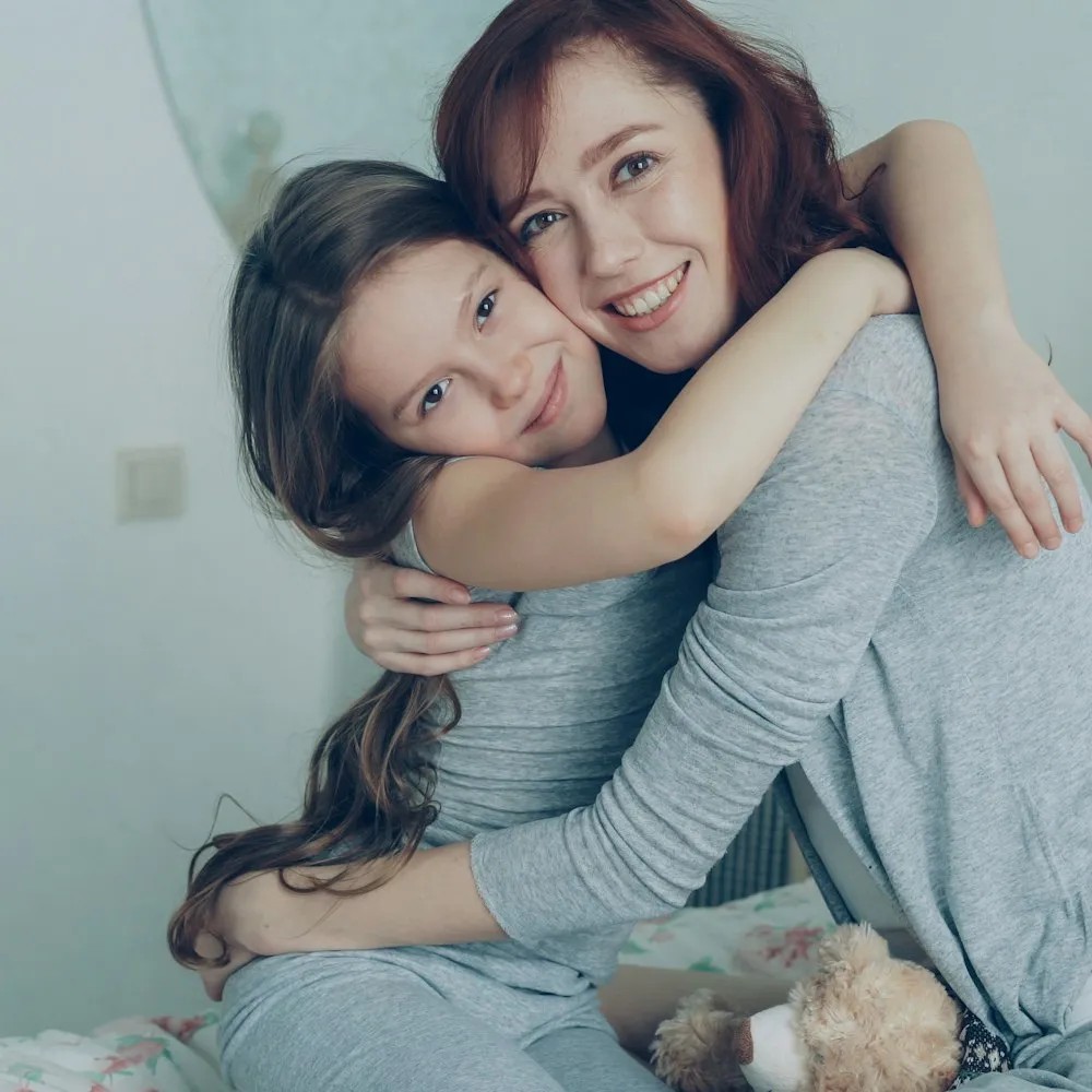 Madre e hija abrazadas y sonriendo